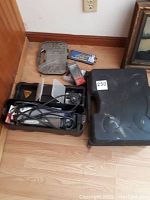 Various drill bit cases and screw extractor set placed on floor alongside the rotary tool case, showing drill bit packagings and extra small tool case.