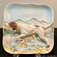 Close up front view of 3D porcelain wall decor plaque showing English Pointer dog and mountain background