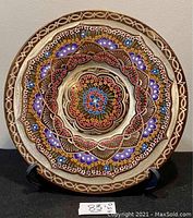 Full frontal view of copper mandala plate on stand showing overall design and pattern detail.