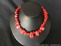 Close-up front view of the red coral bead necklace showing the larger and smaller beads.