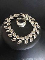 Bracelet and ring shown together on black background