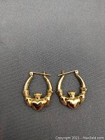 Pair of gold Irish Claddagh earrings front view showing heart and hands design