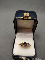Ring displayed in a navy presentation box with white interior