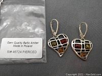 Photo of the pair of sterling silver pierced earrings showing heart shapes with four Baltic amber stones each in a grid design.