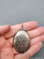 Front exterior showing floral engraving on oval locket