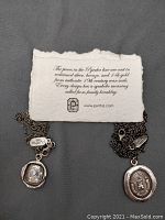 Chain and pendant shown with brand information card describing pieces cast in reclaimed silver, bronze, and 14k gold from authentic 19th century wax seals with symbolic meaning from family heraldry.