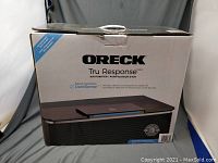 Oreck Tru Response air purifier in its original box showing front branding and DustSense feature.
