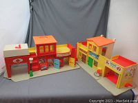 Front view of two connected vintage plastic toy buildings: firehouse and garage theater set