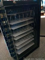 Side angle photo showing the glass window with internal snack spiral racks and trays inside the vending machine.