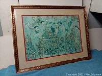 Front view of the framed print showing the artwork portraying people at a bird market with blue-green tones and gilded wood frame.