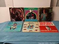 Photo showing 6 vinyl record albums with varied cover art including Mud Slide Slim and The Blue Horizon album by James Taylor