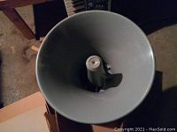 Top view inside the large gray metal speaker horn showing conical shape.