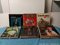 Multiple stacks of vintage easy listening LP records displayed on a table, showing the front covers of some albums including The New Christy Minstrels, Eddie Gorme, and various others.