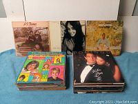 Stacked lot of 51 vinyl LP records visible with partial album covers showing various artists including Joan Baez and Placido Domingo.