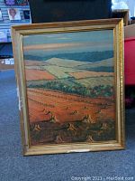 Front view of Britt Lomond landscape painting in gilded frame, showing detailed depiction of farmland and trees.