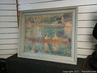Full front view of framed reproduction painting of two figures in a boat on a river scene in soft colors.