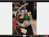 White Nillkin lamp with curved neck and wireless charging base, with accompanying USB power adapter shown on table.