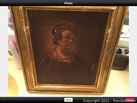 Framed print of Rembrandt self-portrait in golden frame, setup on surface showing general lot condition.