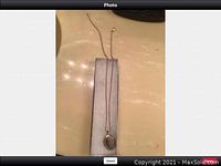 Photo showing the silver chain broken with the oval locket attached, laid out flat on a surface