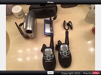 Lot showing two Motorola walkie talkies, digital voice recorder, Bluetooth headset, and Sony camcorder on a surface.