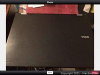 Closed black Dell Latitude laptop with Dell logo on the lid.