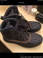 Side view of Nike Woodside 2 boots showing laces, textured upper, orange trim on sole edge.