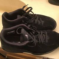 Side view of paired black Air Jordan Franchise sneakers showing profile and laces fully loosened