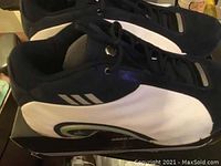 Side angle photo of black and white Adidas men's sneakers, size 13.