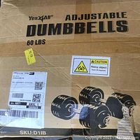Box showing Yes4All Adjustable Dumbbells 60 lbs with caution label about heavy weight, includes shipping labels and box damage.