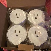 Four new Etekcity smart outlets, each individually wrapped in plastic inside the box