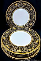 Front view of stacked plates showing black and gold ornate border