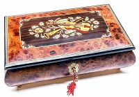 Top angled view of the vintage musical jewelry box showing the violin and floral inlay on the lid, burl wood veneer finish, and the brass lock with red tassel.