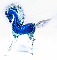Front angle of vintage art glass horse figurine showing blue glass body with clear glass legs and mane.