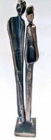Front view of mid century bronze sculpture showing two elongated abstract figures standing on a rectangular base