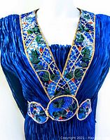 Front detail of V-neckline and waistband embroidery