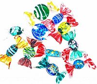 Photo of multiple assorted figural art glass candies in bright colors with twisted end wrappers on a white background.