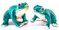 Front angled view of two green ceramic frog salt and pepper shakers by Fitz & Floyd showing detailed painting and holes on the head for dispensing.