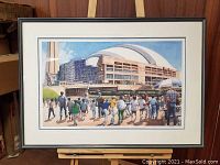 Full view of framed art print showing Toronto Skydome scene on easel against wood wall