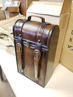 Front view of brown textured decorative box with handle and faux buckle straps closed