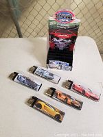 Five oversized lighters with colorful dream car images on a flat surface in front of the retail display