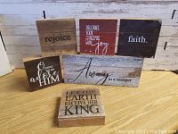 Front view of six wooden Christmas-themed signs displaying various Christmas messages with mixed fonts, colors, and rustic finish