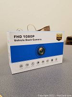 Front view of the product box showing FHD 1080P Vehicle Dash Camera branding and iconography.