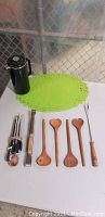 Photo showing black coffee server, green placemats, wooden salad tongs, metal BBQ tools