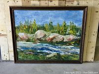 Frontal image of the landscape oil painting depicting a river and trees in a dark wood frame.