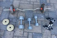 Overview of EZ curl barbell loaded with plates, hex dumbbells, York plates, push-up bars