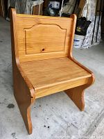 Front view of the pine wood church bench showing the carved back panel and seat surface