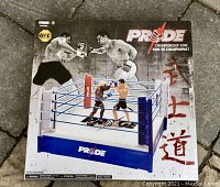 Front of the Pride Championship Ring box showing two fighters in a boxing ring with 'Pride' logo and Japanese characters on the side.