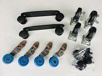 Four castor wheel sets including black twin-wheel handles, black metal single wheels with brakes, and blue vintage single castors on metal brackets.