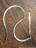 Full view of chain laid on wooden surface showing overall length and condition