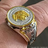 Close-up photo of ring showing the face with a gold-tone profile of Donald Trump and 'Trump USA' inscription on the sides.